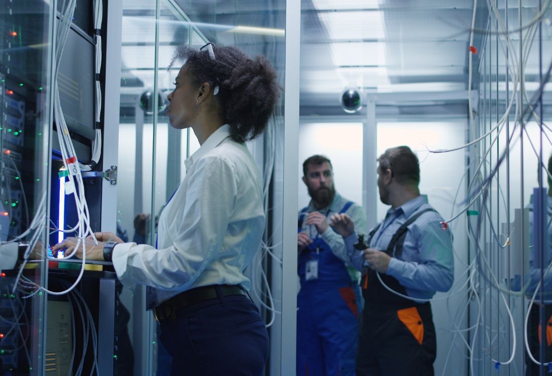 Woman working with cables in data centre Implementing The Six Components of Structured Cabling